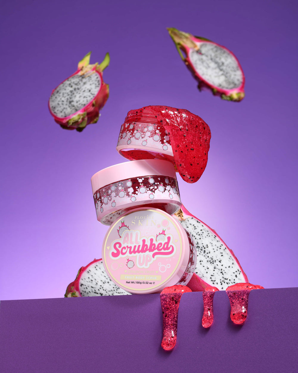 Frasco de P. Louise All Scrubbed Up Esfoliante corporal com fruta do dragão em fundo roxo