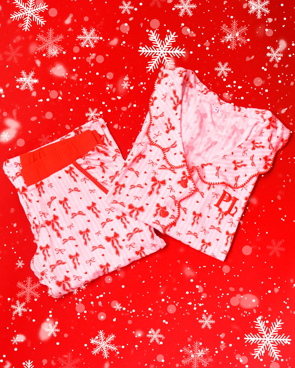 Par de pijama listrado rosa e branco com desenhos de laço festivo vermelho em um fundo vermelho com flocos de neve