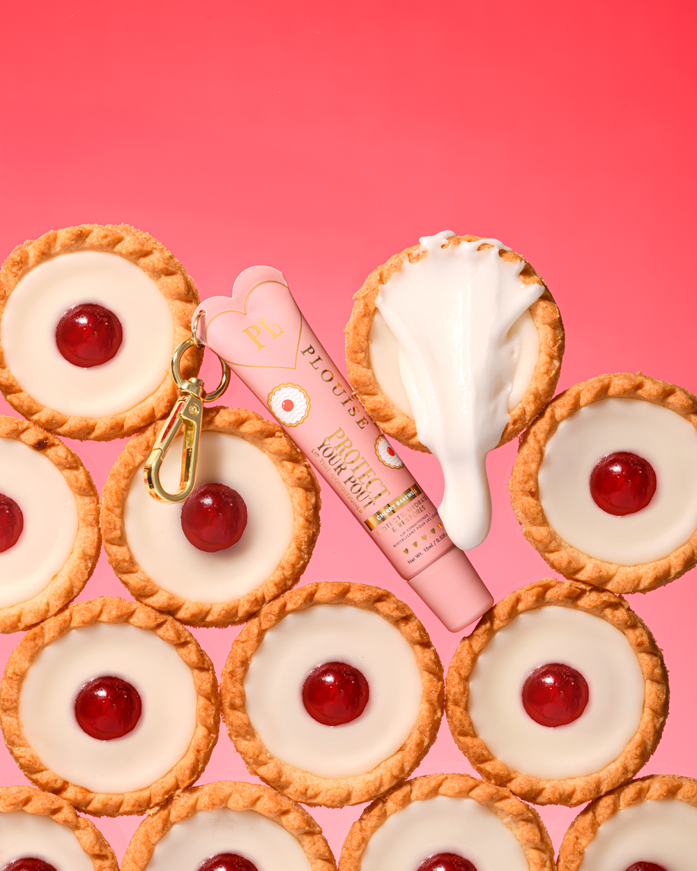 Condicionador labial com aroma de cereja rosa e amêndoa protege seu beicinho com clipe dourado colocado entre sobremesas de cereja