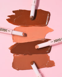 Muestras de los bálsamos de lápiz labial brillante P.Louise Glow Guide sobre un fondo rosa