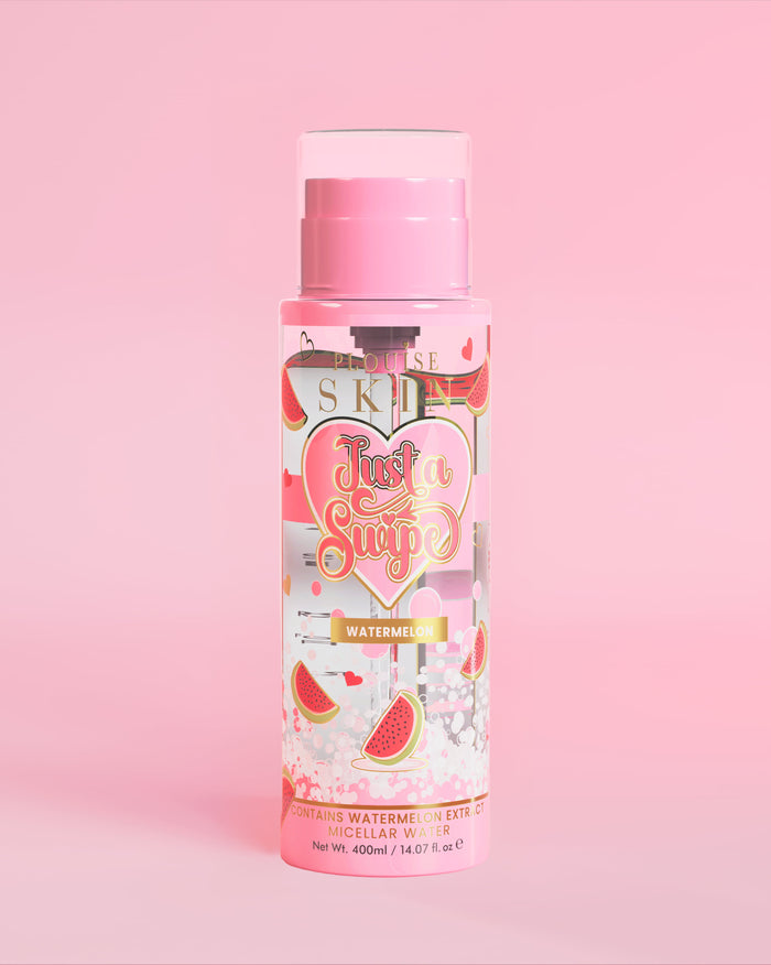 Uma garrafa de água micelar perfumada de melancia P. Louise Just A Swipe com desenho de melancia no frasco contra um fundo rosa