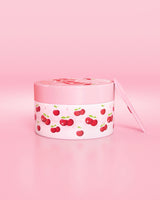 Recipiente rosa com desenho de cereja em um fundo rosa