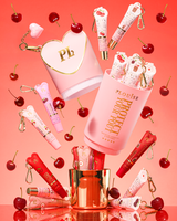 Conjunto de presente Pink XL Protect Your Pout que é aberto cercado por cerejas e condicionadores labiais rosa e vermelhos em um fundo rosa