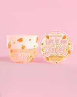 Tarro de manteca corporal de mango P. Louise 'Lay It On Thick' sobre fondo rosa