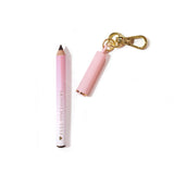 Delineador labial mini chaveiro rosa P.Louise com a marca 'Full Disclosure' em um fundo rosa claro