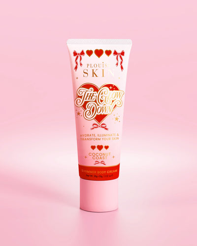 Tubo rosa de creme corporal brilhante P.Louise The Glow Down com aroma de costa de coco contra um fundo rosa