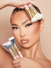 Una imagen de una modelo maquillada sosteniendo el juego de brochas de maquillaje de 5 piezas Spoiled For Choice de P.Louise contra su rostro.