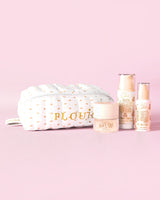 Una imagen de P.Louise The Softest Touch Skincare Starter Kit con un osito de maquillaje con estampado pequeño y una bolsa para el cuidado de la piel que incluye 3 productos para el cuidado de la piel sobre un fondo rosa.